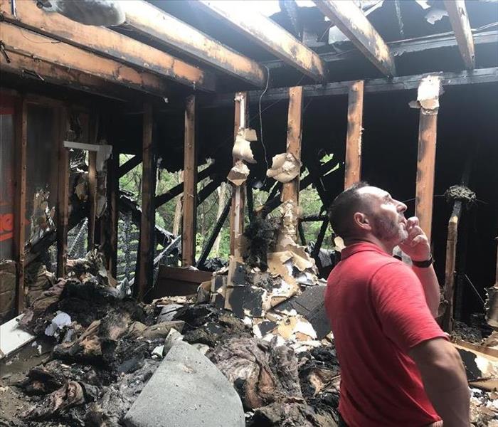 man in a red shirt in a home with a fire loss